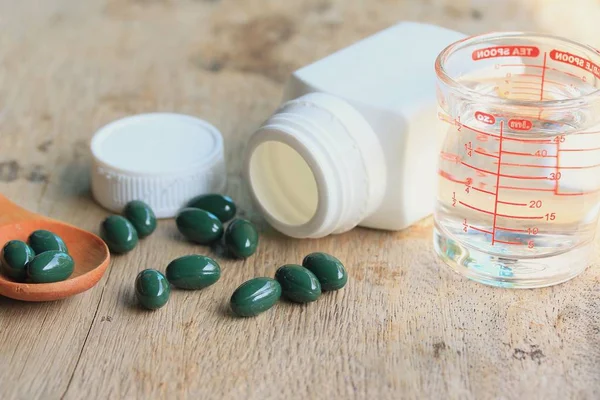 Pílulas de vitaminas na madeira — Fotografia de Stock