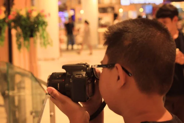 Blurred people using a camera to take photo — Stock Photo, Image