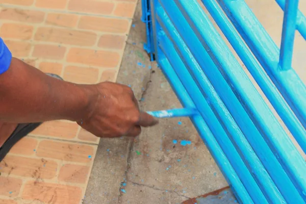 Mannen geschilderd stalen hek — Stockfoto