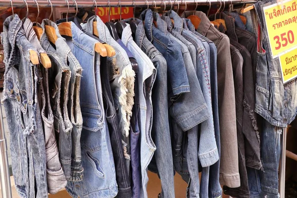 Jeans clothes on hangers — Stock Photo, Image