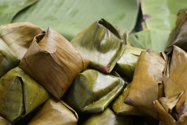 Dough wrapped in banana leaves — Stock Photo, Image