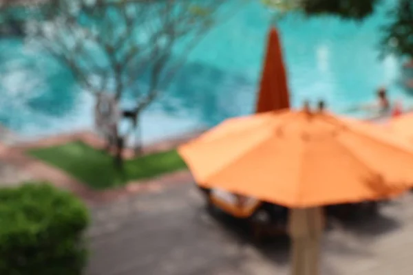 Blurred swimming pool with umbrellas — Stock Photo, Image
