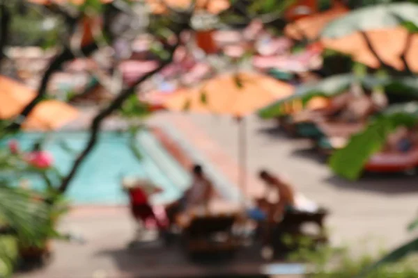 Verschwommenes Schwimmbad mit Sonnenschirmen — Stockfoto
