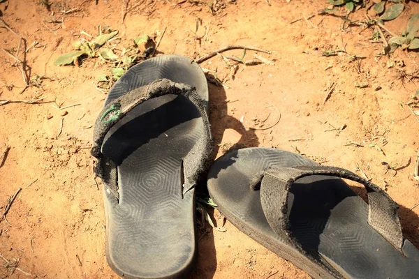 Vecchia pantofola nera a terra — Foto Stock
