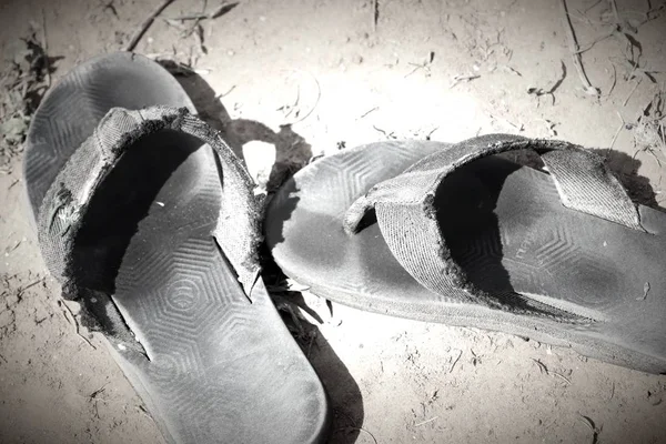 Vecchia pantofola nera a terra — Foto Stock