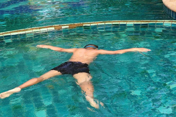 男孩在游泳池中游泳 — 图库照片