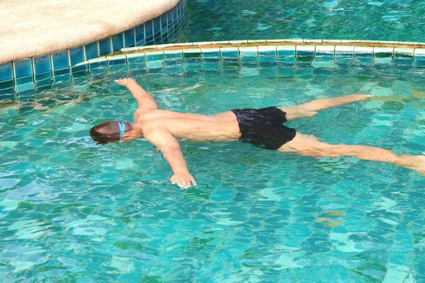 男孩在游泳池中游泳 — 图库照片