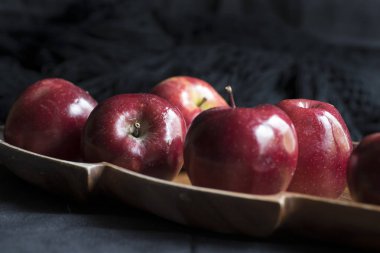 Elmalar kırmızı ve parlak, iştah açıcı, masada.