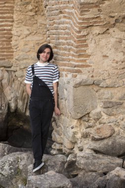 Tarlada poz veren ve arka planda köprüsü olan genç bir adam. Açık havanın tadını çıkarıyorum.