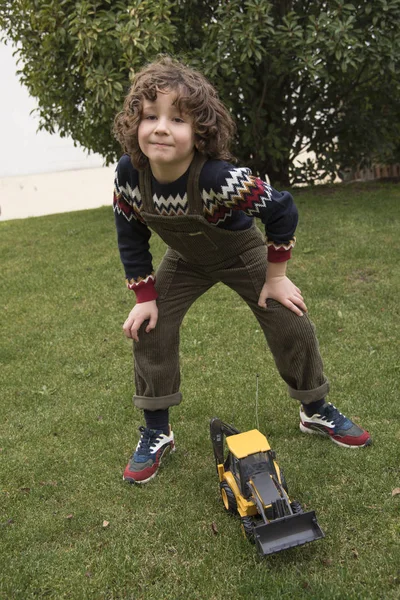 Little Boy Curly Hair Posing Green Bib Toy Machine — 스톡 사진