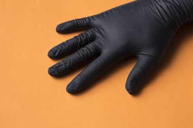 siyah hijyenik eldiven bir elde, turuncu arka planda