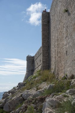 Dubrovnik, Hırvatistan ve Avrupa 'daki taş duvarın ve üzerinde durduğu kayaların yan görüntüsü.