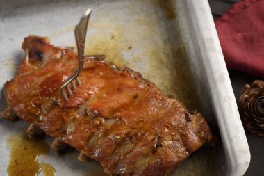 Fırında domuz kaburgası ve çatal saplanmış.