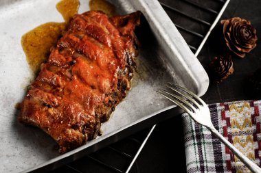 Kızarmış domuz kaburgası, bir tepside ve bir rafta.