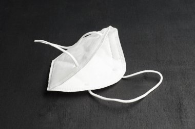 Siyah arka planda beyaz yüz maskesi. Bulaşıcı hastalığı önlemek için koruyucu..