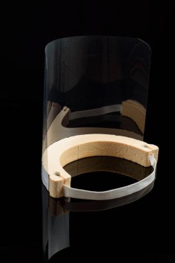 Siyah arkaplanda, şeffaf yüz ekranı. Bulaşıcı hastalığı önlemek için koruyucu.