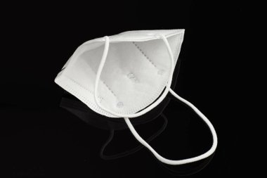 Siyah arka planda beyaz yüz maskesi. Bulaşıcı hastalığı önlemek için koruyucu..