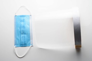 Beyaz arka planda, şeffaf yüz ve maske. Salgını önlemek için koruyucular.