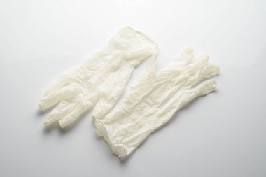 Beyaz arka planda bej lateks eldivenler. Bulaşıcı hastalığı önlemek için koruyucu..