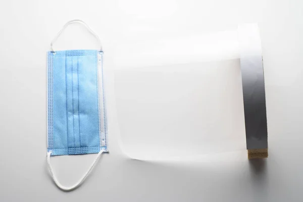 Beyaz arka planda, şeffaf yüz ve maske. Salgını önlemek için koruyucular.