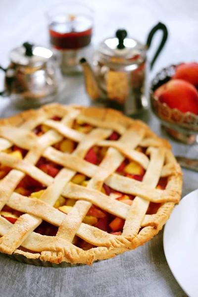 Tasty summer fruit pie with peach filling, tea and cookies