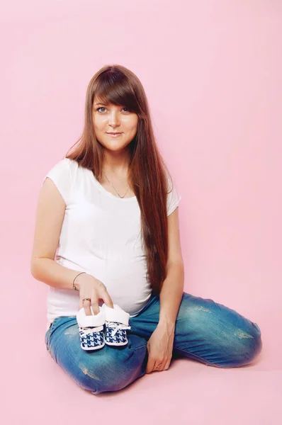 Pregnant woman in jeans and white tee shirt