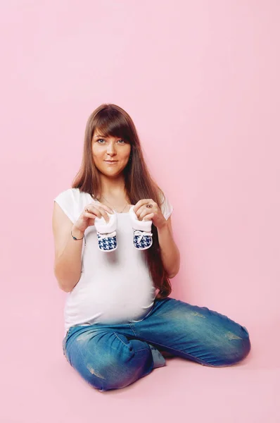 Zwangere vrouw in jeans en t-shirt wit nemen — Stockfoto