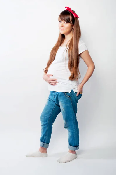 Těhotná žena v neformálním oblečení s dlouhými vlasy — Stock fotografie