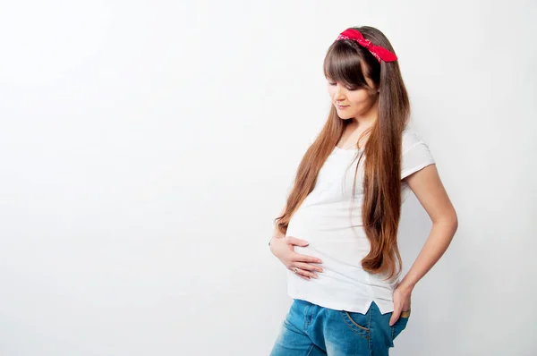 Těhotná žena v neformálním oblečení s dlouhými vlasy — Stock fotografie