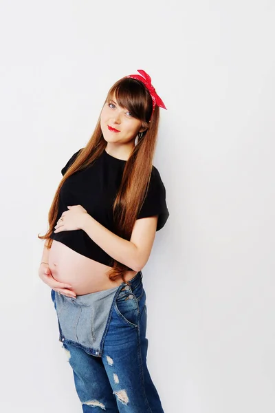 Mulher grávida em camiseta preta e macacão jeans — Fotografia de Stock