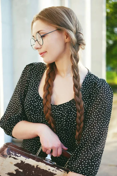 Jeune étudiante femme avec une valise et de longues tresses — Photo