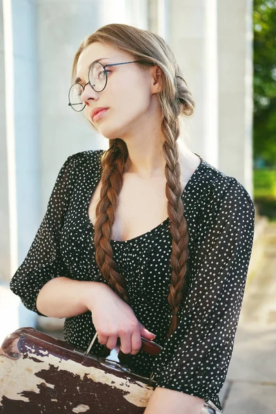 Jeune étudiante femme avec une valise et de longues tresses — Photo