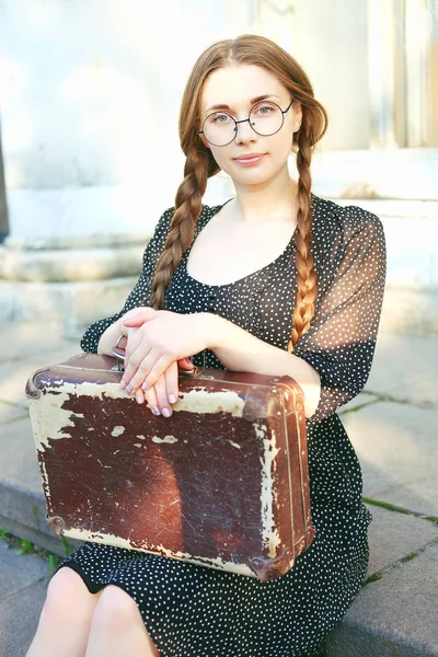 Молода студентка з валізою і довгими косами — стокове фото