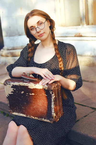 Junge Studentin mit Koffer und langen Zöpfen — Stockfoto