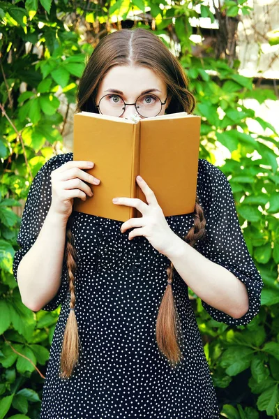 Joven estudiante con trenzas largas y una novela romántica —  Fotos de Stock