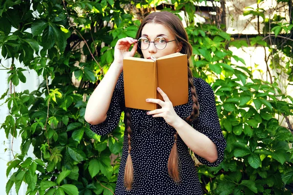 Joven estudiante con trenzas largas y una novela romántica —  Fotos de Stock