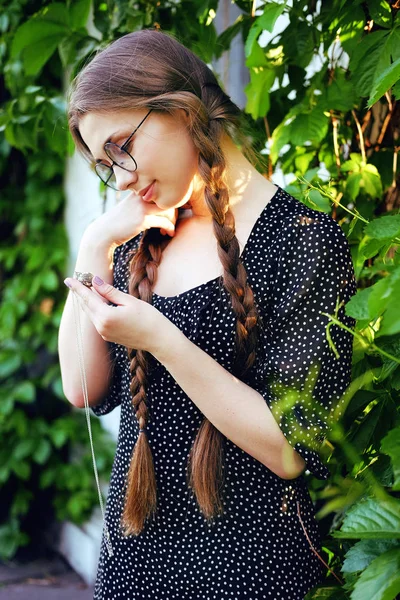 Portrait de jeune femme dans des lunettes regardant cadeau médaillon d'argent — Photo