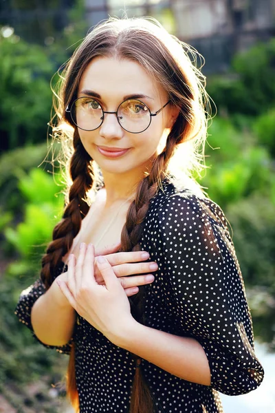 Porträt einer jungen Frau mit Brille beim Anblick eines silbernen Medaillons — Stockfoto