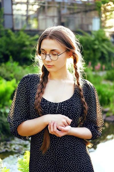 Retrato de mujer joven en gafas mirando medallón de plata regalo — Foto de Stock