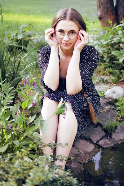 Young naive village girl with long braids and glasses — Stock Photo, Image