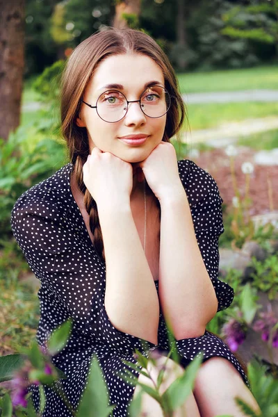 Joven ingenua chica del pueblo con trenzas largas y gafas — Foto de Stock