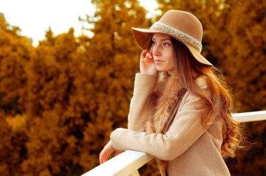 Kadın uzun kızıl saçlı, fedora şapka ve kürk ceket