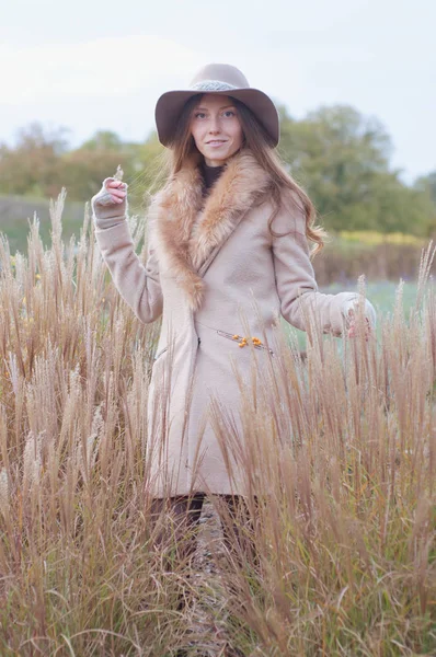 Mulher de casaco de pele bege no campo seco de outono — Fotografia de Stock