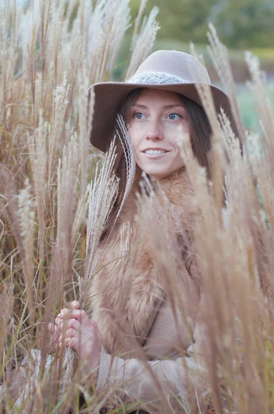 Mulher de casaco de pele bege no campo seco de outono — Fotografia de Stock