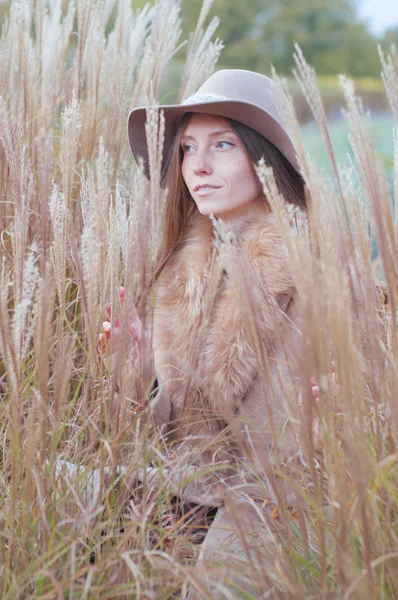 Femme en manteau de fourrure beige dans le champ sec d'automne — Photo