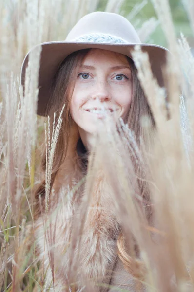 Donna in pelliccia beige nel campo asciutto autunnale — Foto Stock