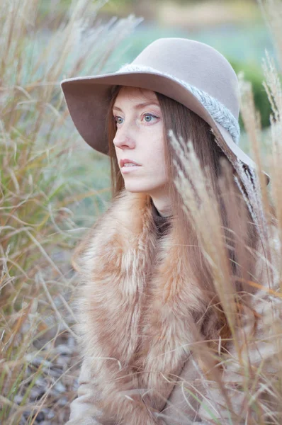 Woman in beige fur coat in the dry autumn field — Stock Photo, Image