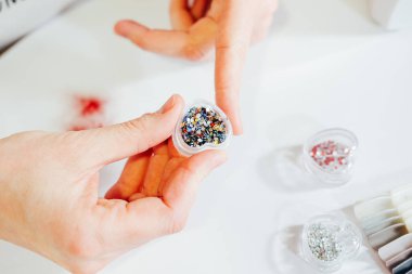 Makyaj ve manikür için bir kutu içinde çeşitli renklerde rhinestones