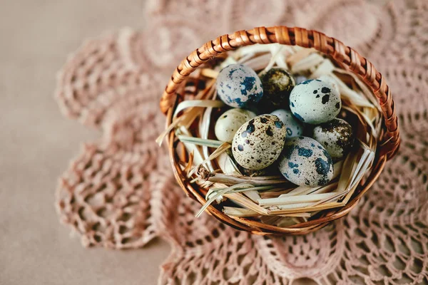 Easter holiday decoration.  Quail eggs wrapped in hay in woven b — Stock Photo, Image