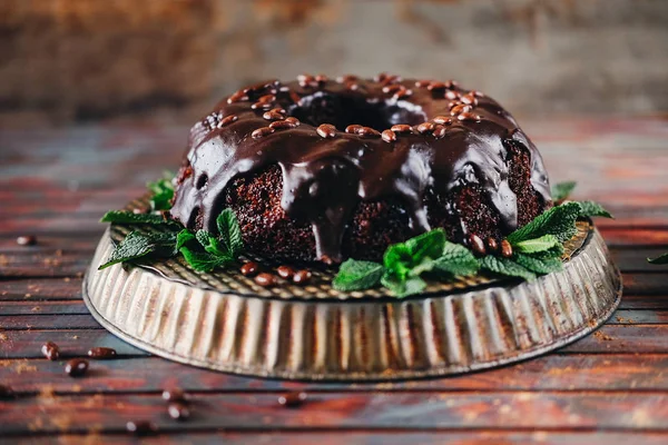 Sweet chocolate cake with cacao icing and decorated with mint